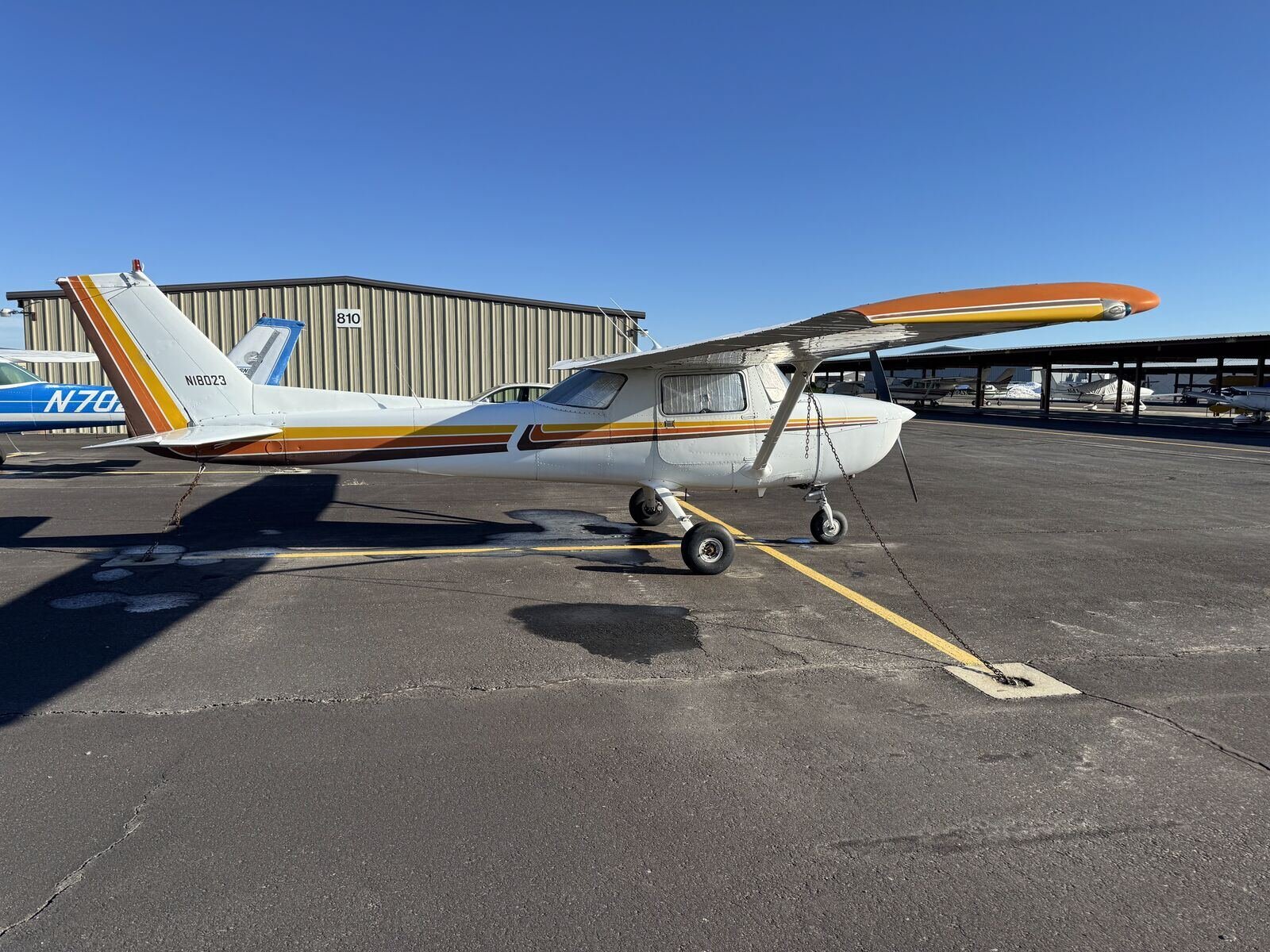 Cessna 150L N18023 tied down on the ramp under a clear blue Idaho sky